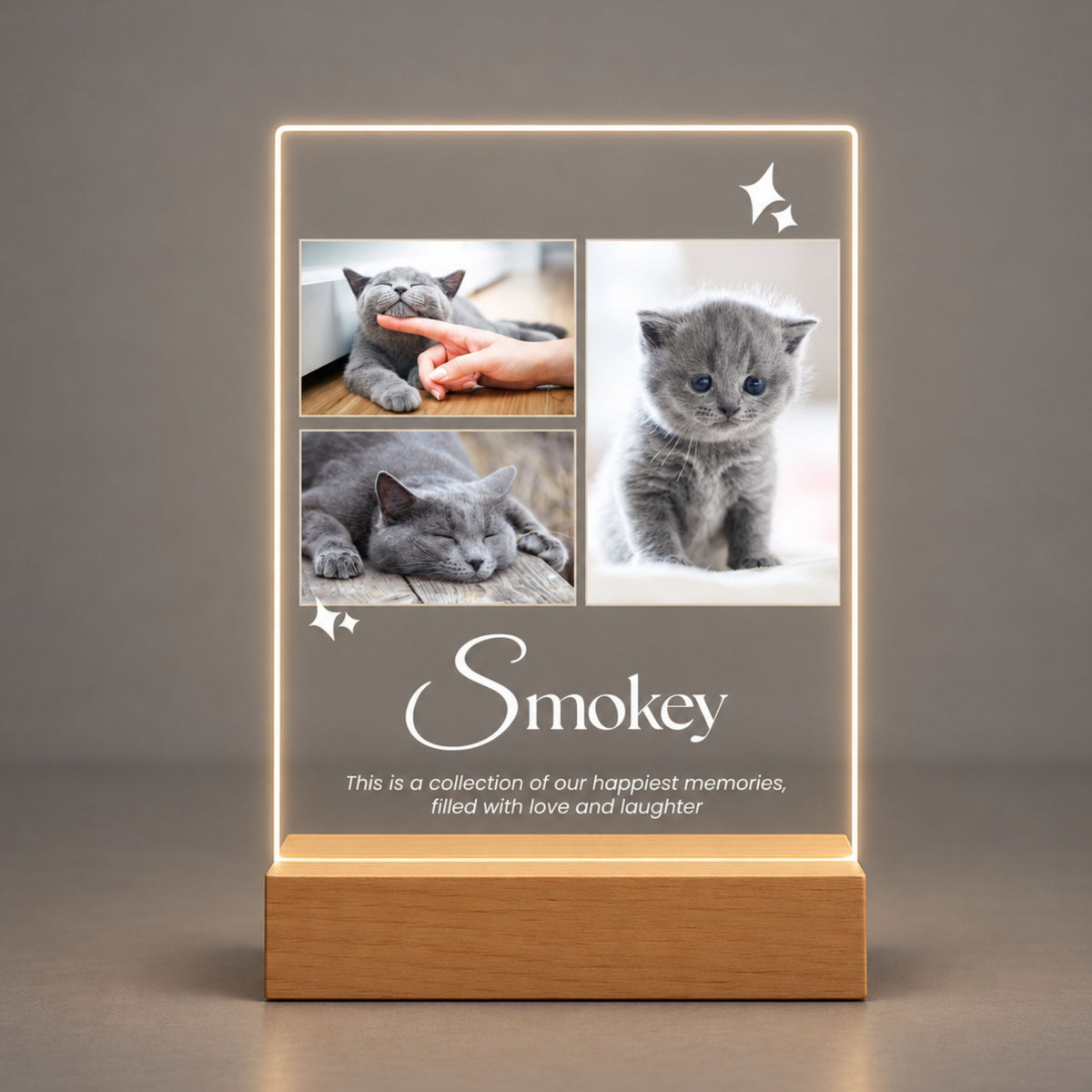 Studio front view of illuminated three-picture cat keepsake acrylic plaque glowing warm white on a natural wooden LED base.
