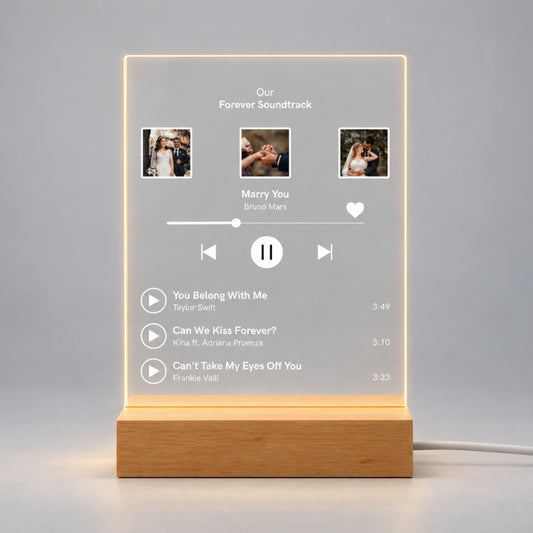 Studio front view of illuminated custom music playlist acrylic plaque with 3 wedding photos and song list glowing warm white on a wooden LED stand.