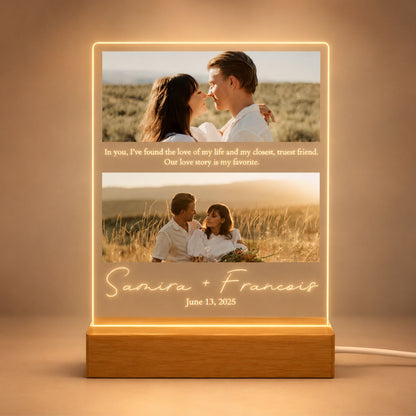 Studio front view of illuminated two-picture couple acrylic plaque glowing warm white on a natural wooden LED stand.
