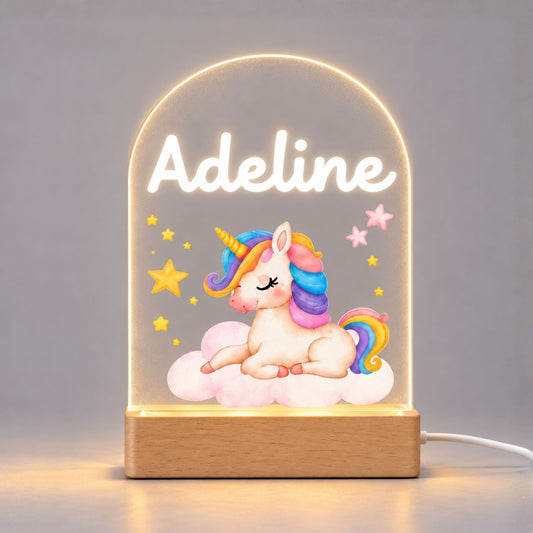 Illuminated baby unicorn acrylic night light on a plain light background, with a personalized name above the artwork and a wooden base.