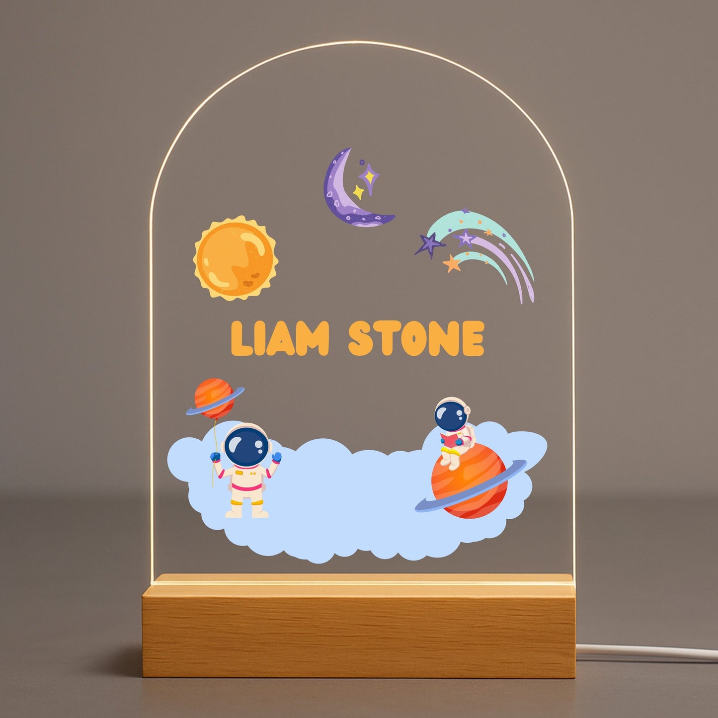 Personalized astronaut kids night light with custom name on clear acrylic sheet, set in a natural wood base