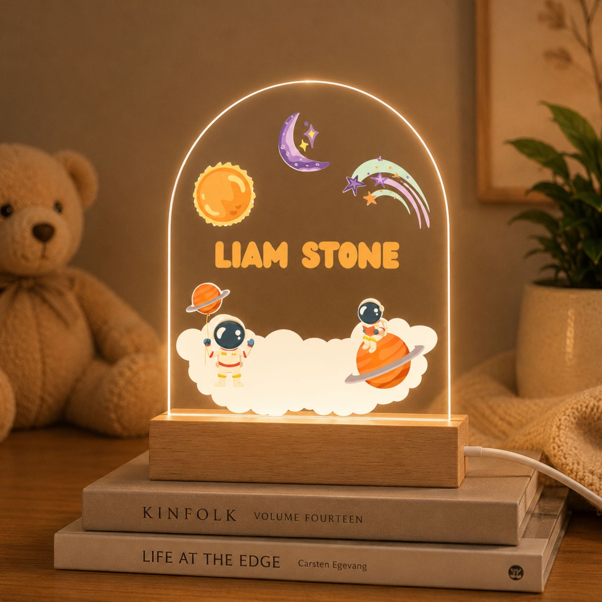 Illuminated custom astronaut nursery lamp casting a soft warm yellow LED glow in a dimly lit children's room.