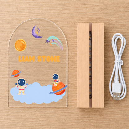 Handcrafted solid wood base of a custom name space light on a clean, bright minimalist surface.