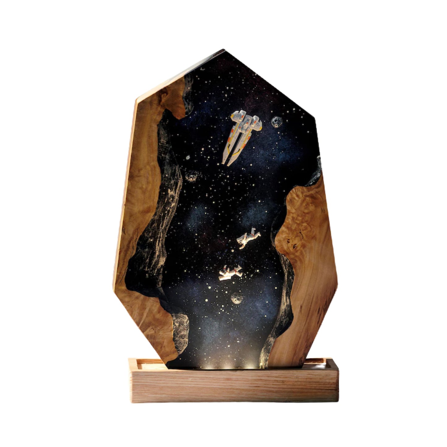 A handcrafted hexagonal resin lamp featuring a deep space scene with a spaceship and two astronauts drifting between two natural wood edges.