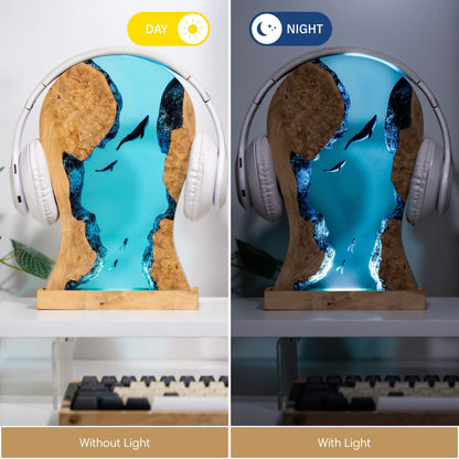 Resin whale LED headphone stand holding over-ear headphones on a desktop with ambient LED lighting, lifestyle view