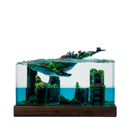 the handmade blue whale and underwater ruins epoxy resin lamp on a wooden base against white background