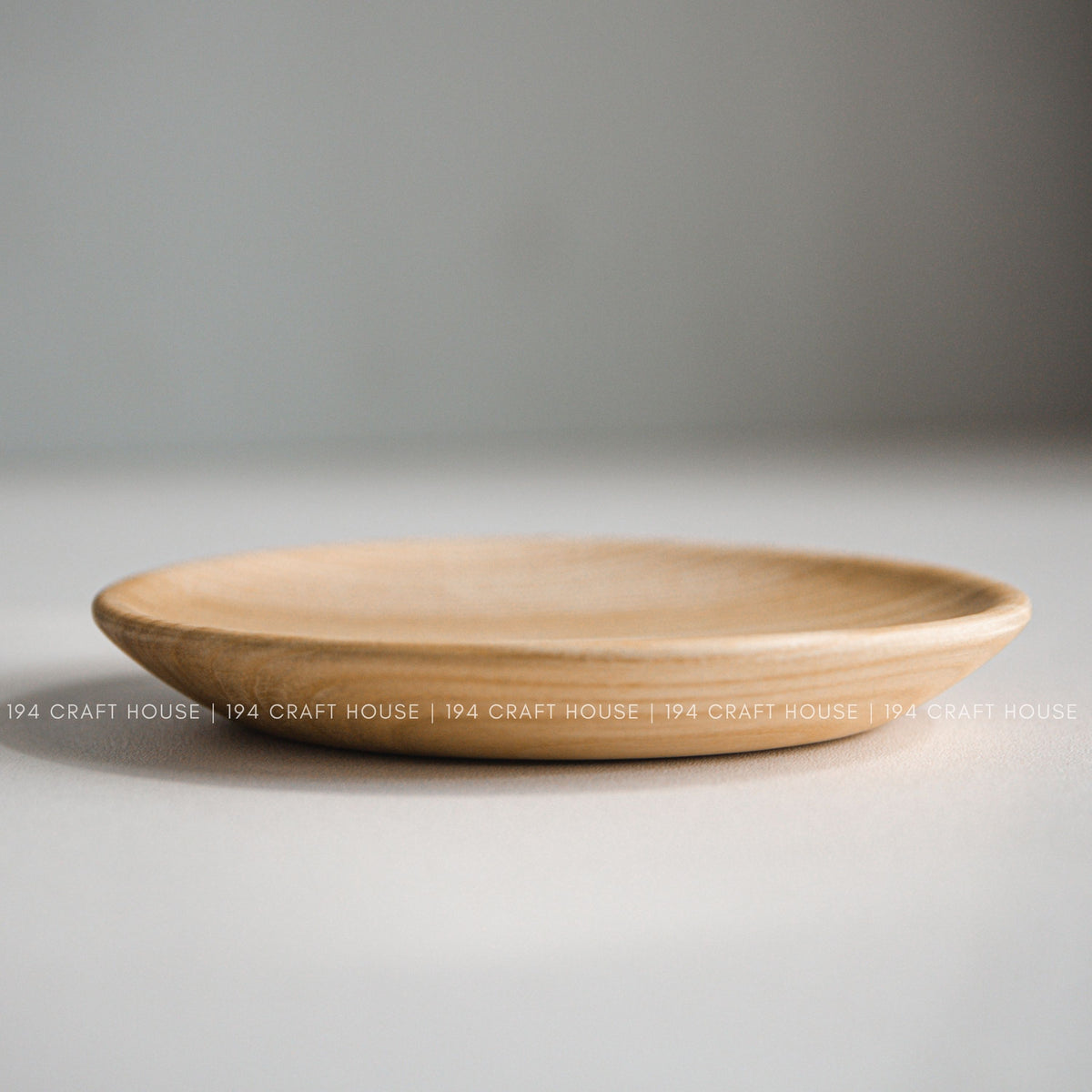 Low side view showing the shallow shape and rounded rim of a wood plate