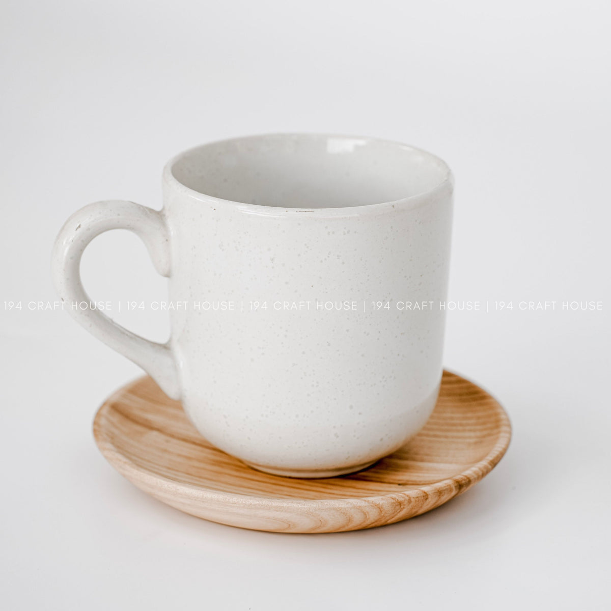 White mug resting on a round wood plate on a bright tabletop