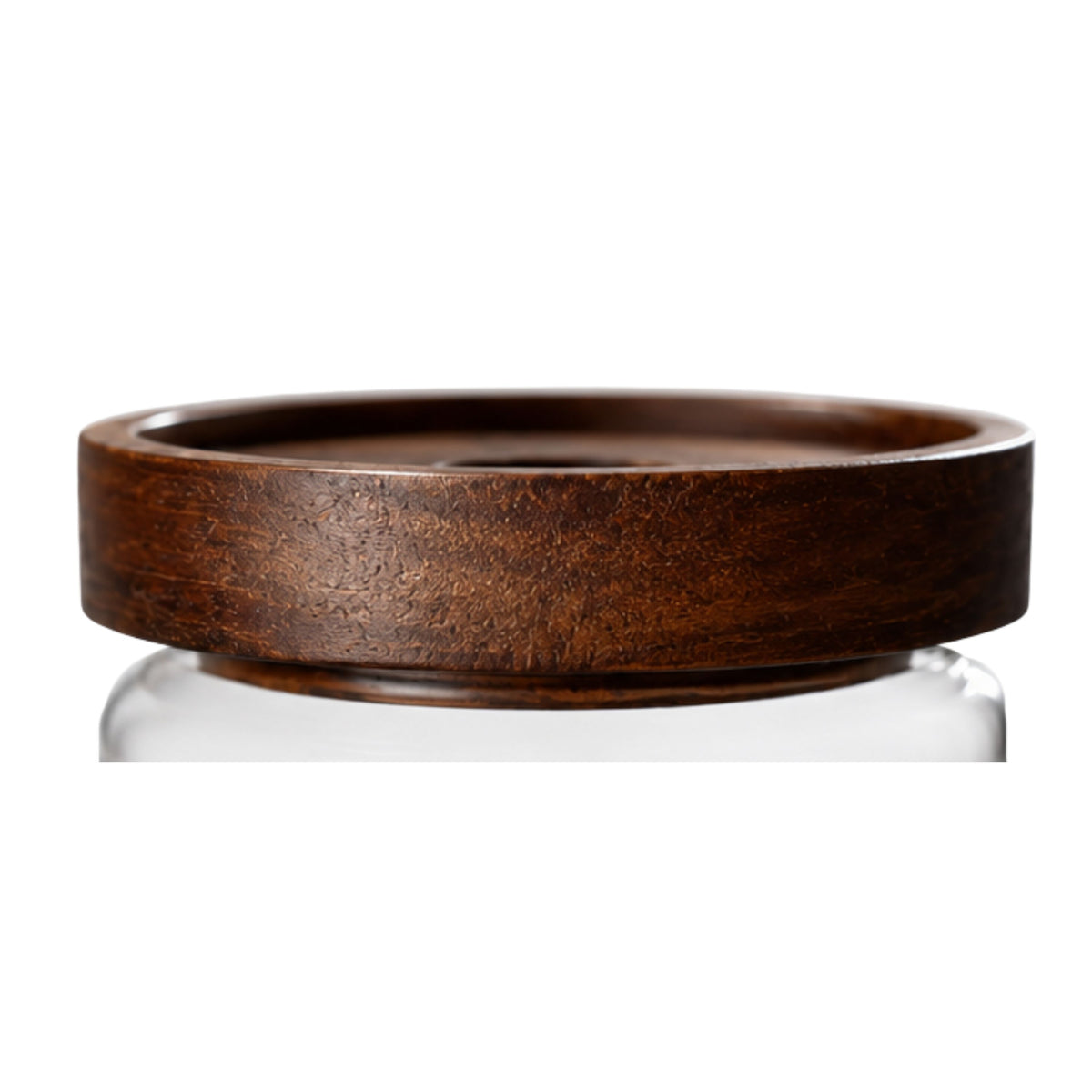 Close-up side profile of a thick dark grain wooden replacement lid fitted securely onto a clear glass storage jar.
