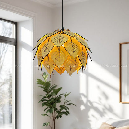 Lit bodhi leaf wood pendant hanging in bright living room near window and plant