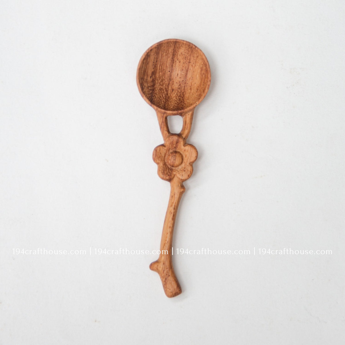 Front view of a handcrafted flower handle Doussie wood spice spoon on a clean white background.