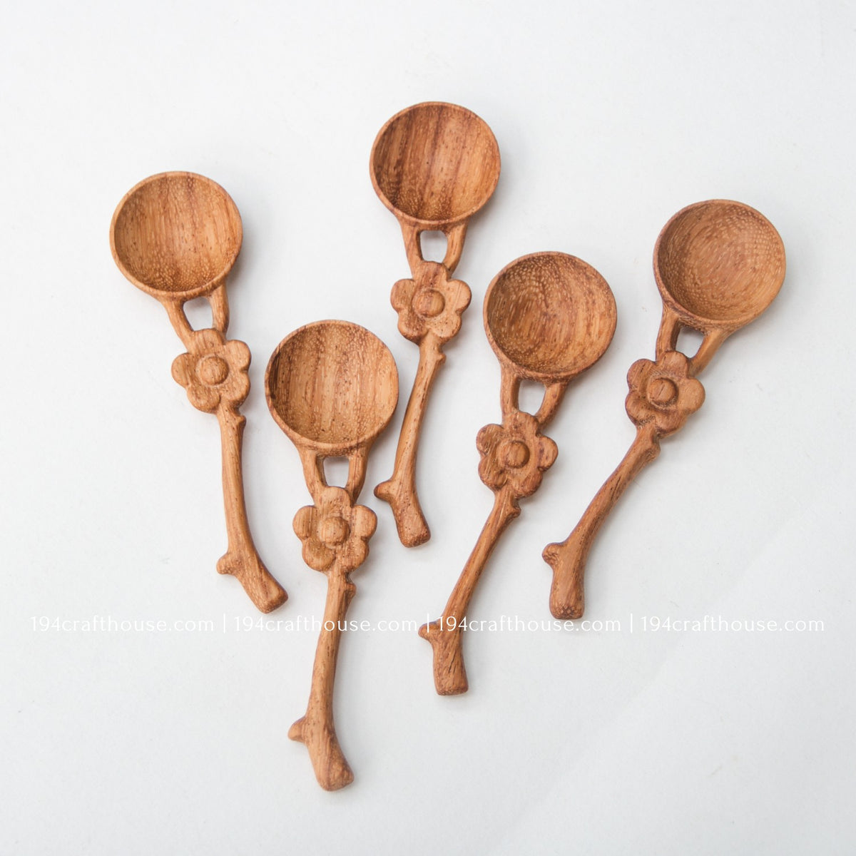 Group of five handcrafted flower handle Doussie wood spice spoons showing natural grain and handmade variation.