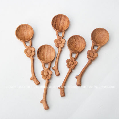 Group of five handcrafted flower handle Doussie wood spice spoons showing natural grain and handmade variation.